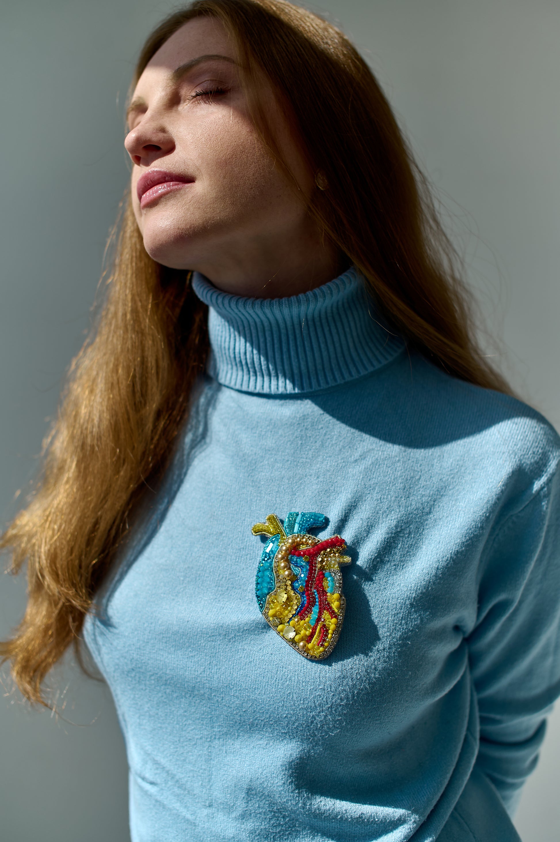 Model wearing the Anatomical Heart Embroidered Brooch pinned on a jacket, highlighting its artistic design and craftsmanship