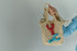 Close-up view of the intricate beadwork and secure fastening on a handmade lobster brooch, highlighting its vibrant red/blue color and ocean-inspired design