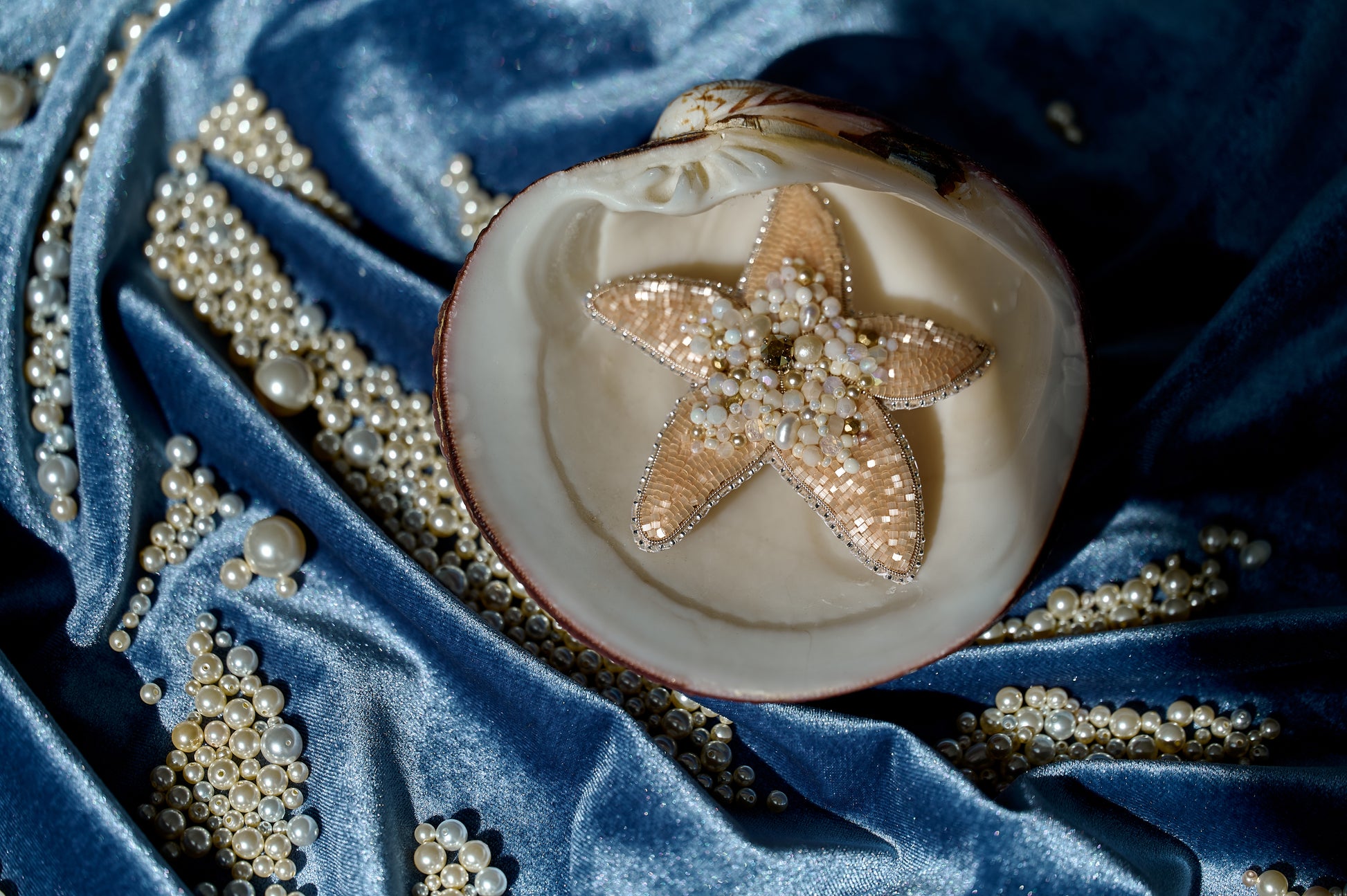 Model wearing the Stellar Seas Starfish Brooch as a statement accessory, highlighting its ocean-inspired design with warm peach, beige, and golden tones.