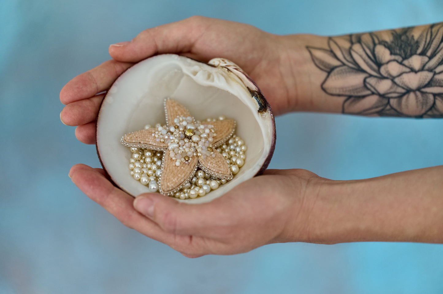Handcrafted Stellar Seas Starfish Brooch featuring intricate embroidery with Japanese beads, assorted beads, shimmering crystals, and pearls in warm peach, beige, and golden hues. Measures 3.51 inches by 3.12 inches (9 cm x 8 cm).
