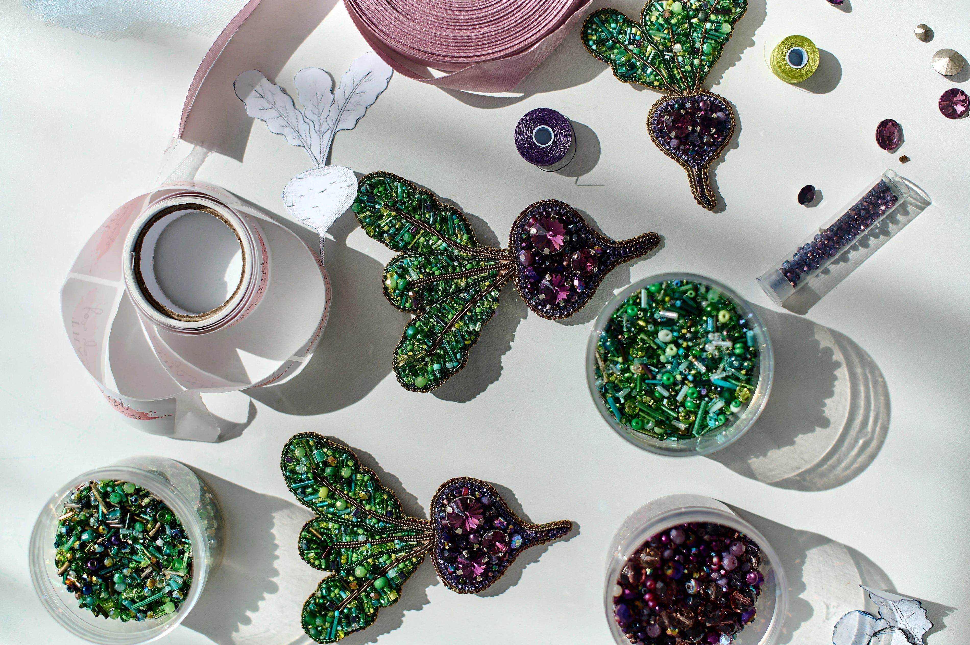 Decorative brooches with gemstones on a white surface