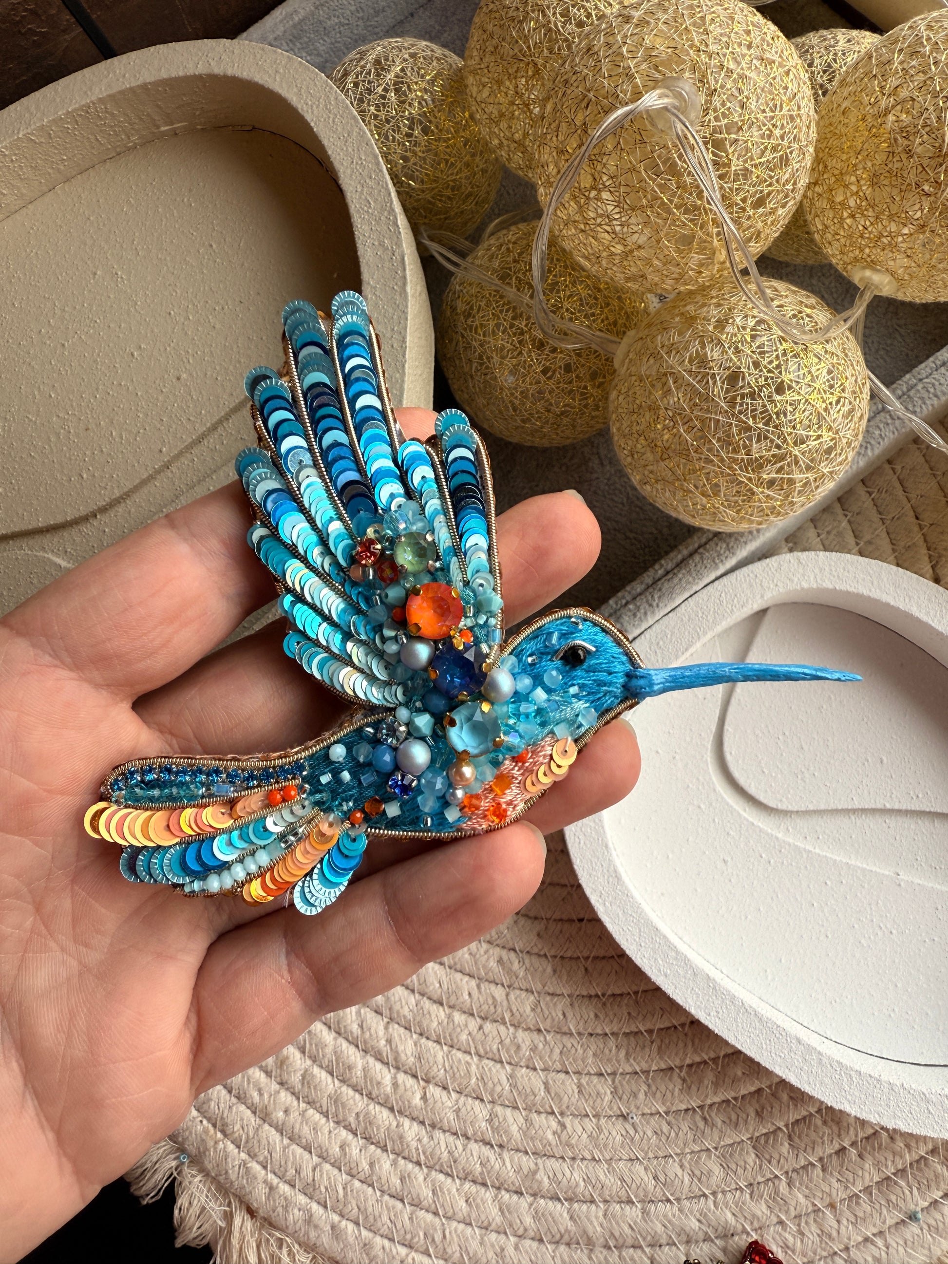 Blue hummingbird beaded brooch hand embroidered with turquoise sequins, orange accents, crystals, beads, and sparkling wing details