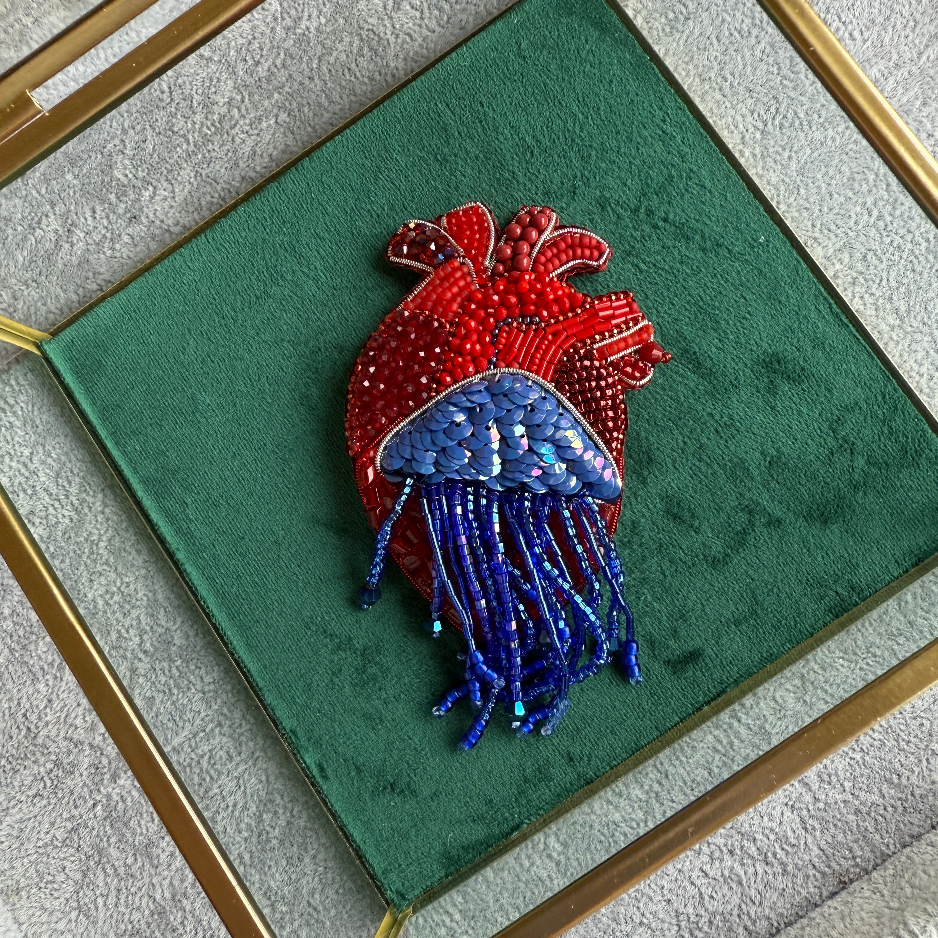 Decorative heart-shaped object with red and blue elements on a green background