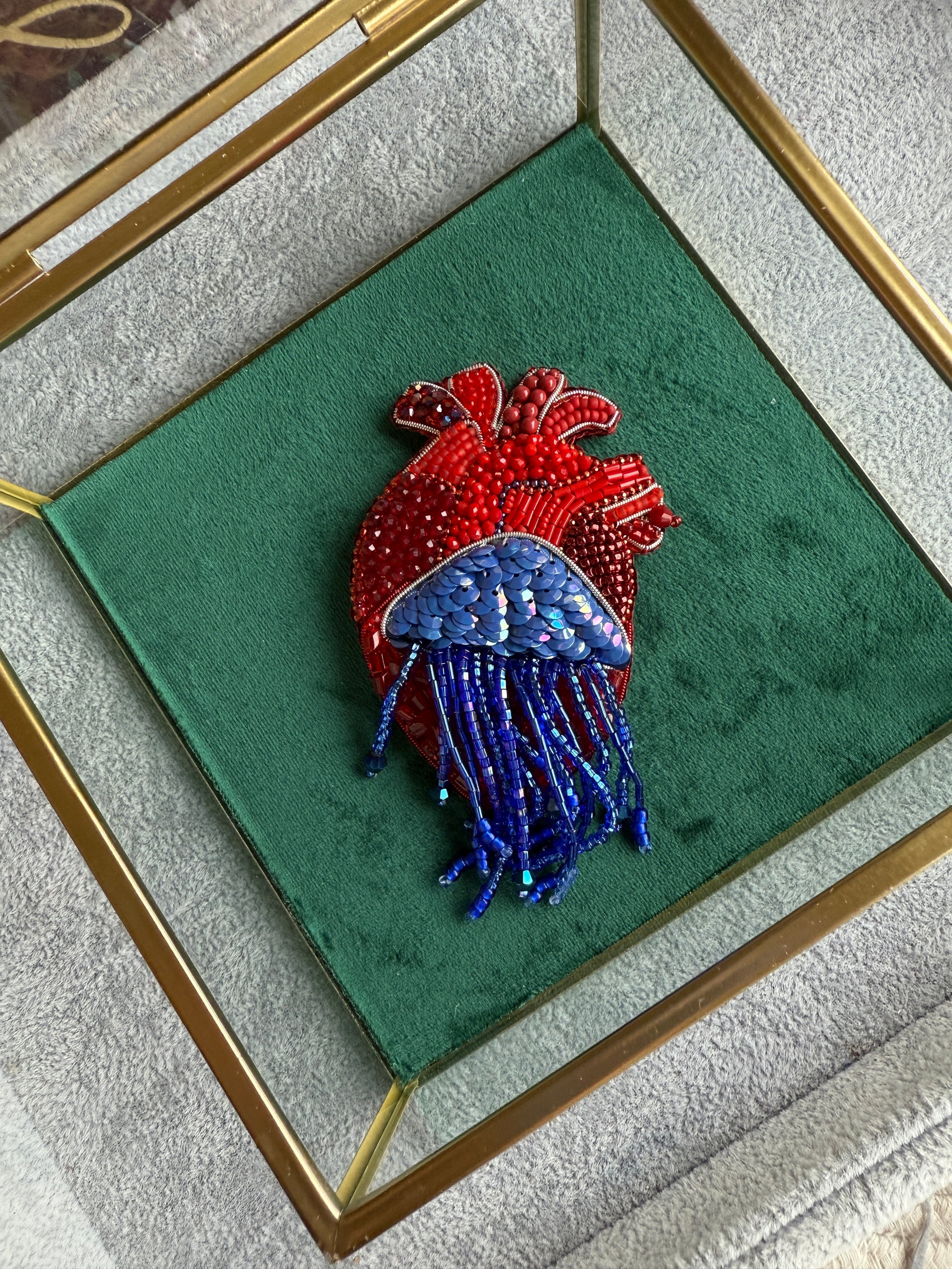 Decorative heart-shaped object with red and blue elements on a green background
