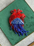 Red and blue beaded crab on a green fabric background