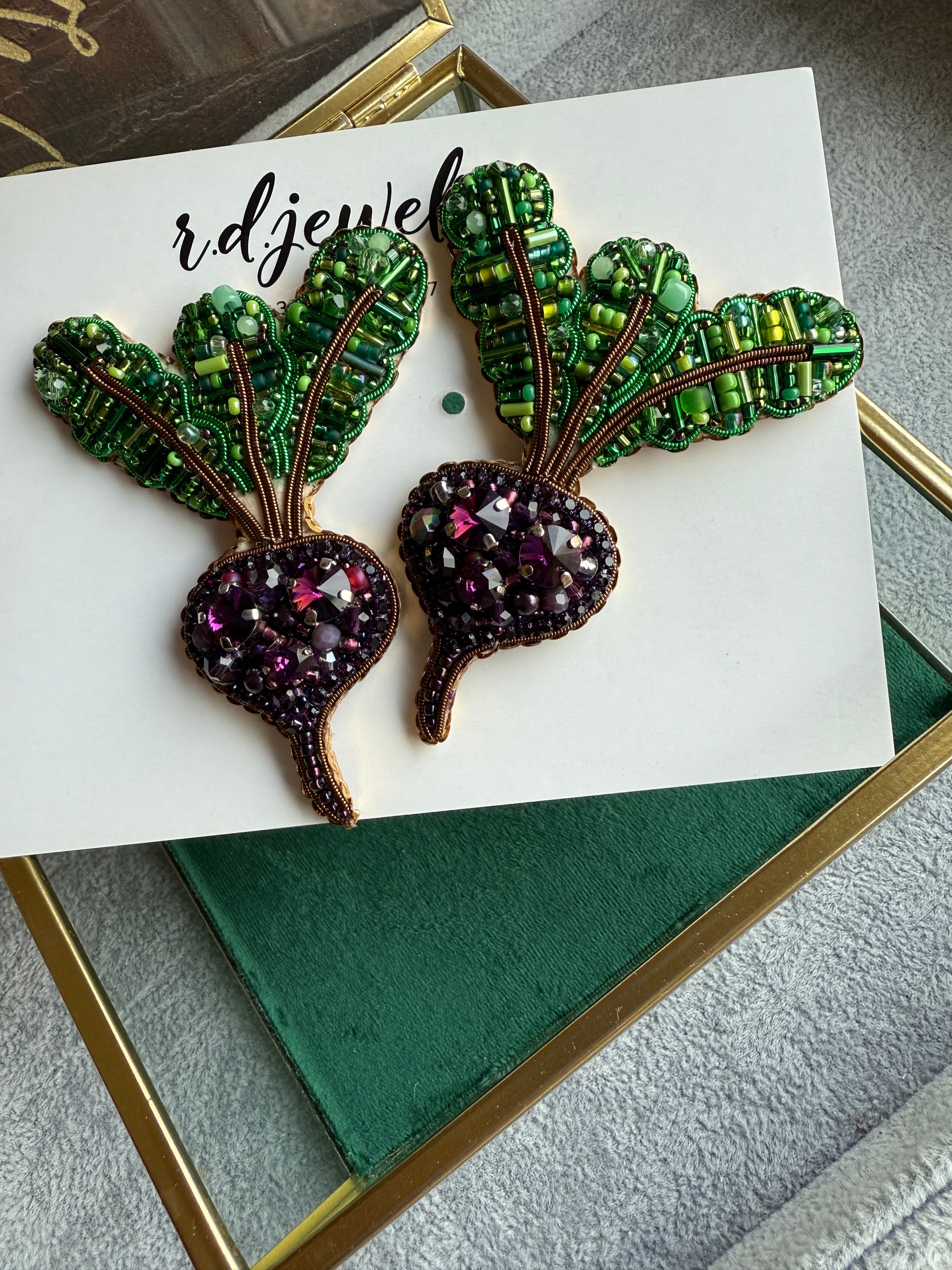 Handmade purple beet earrings with green leafy tops and sparkling violet crystals, embroidered with beads and inspired by fresh garden vegetables.