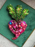 Decorative brooches with green leaf-like design and pink flower-like design on a green background