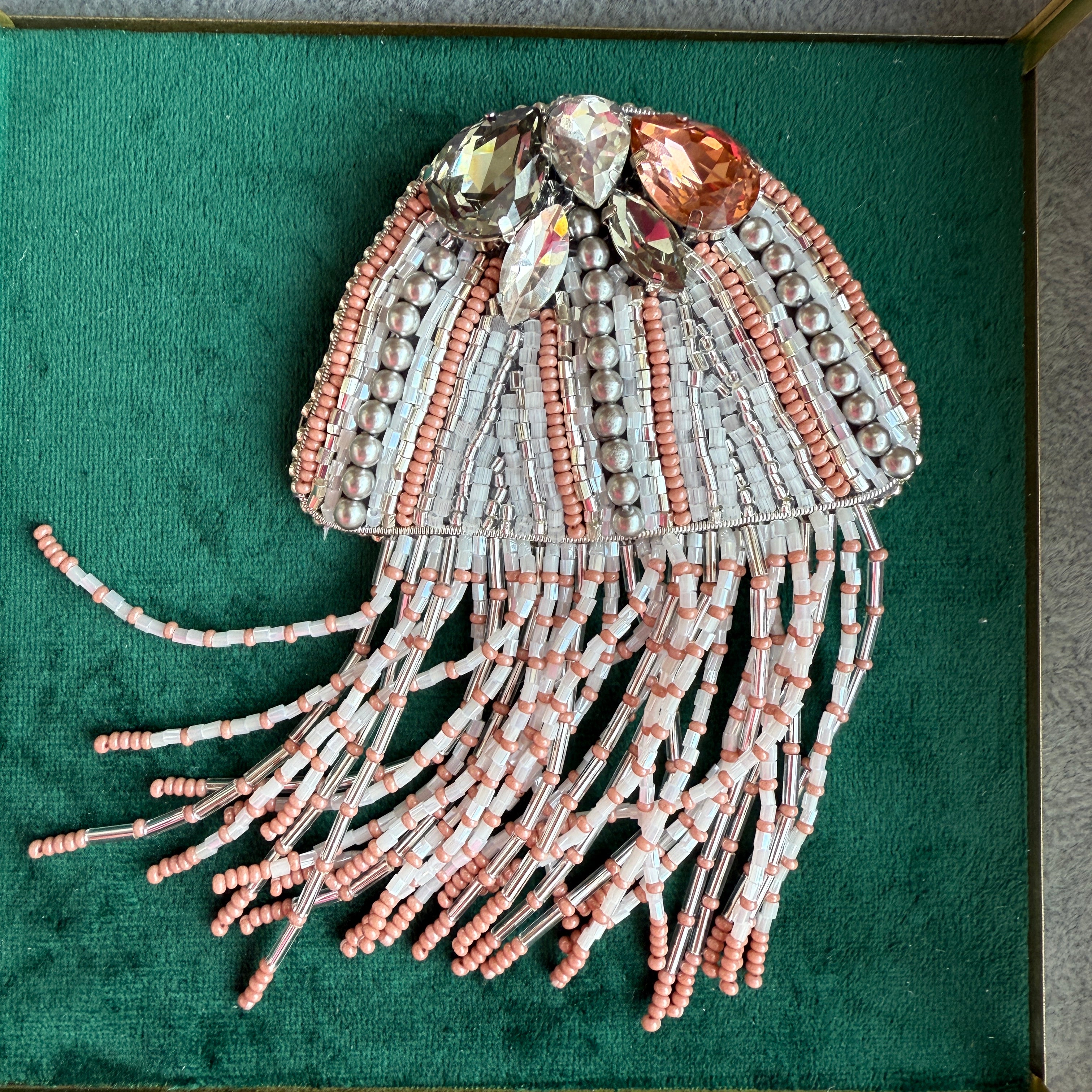 Decorative jellyfish sculpture with beads on a green background