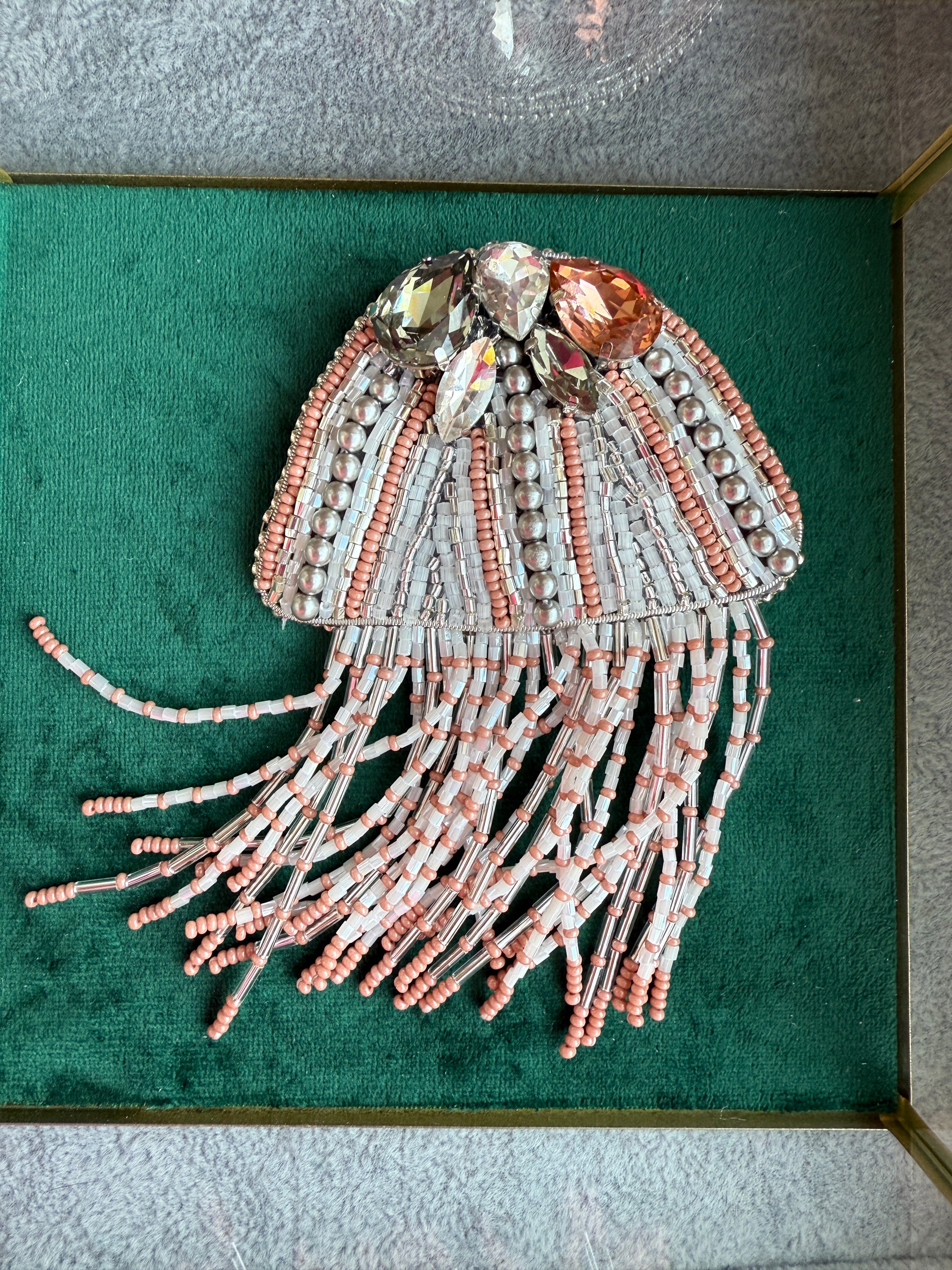 Decorative jellyfish sculpture with beads on a green background