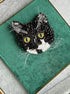 Custom black and white cat portrait beaded brooch hand embroidered with black beads, white whiskers, green eyes, crystals, and detailed pet embroidery