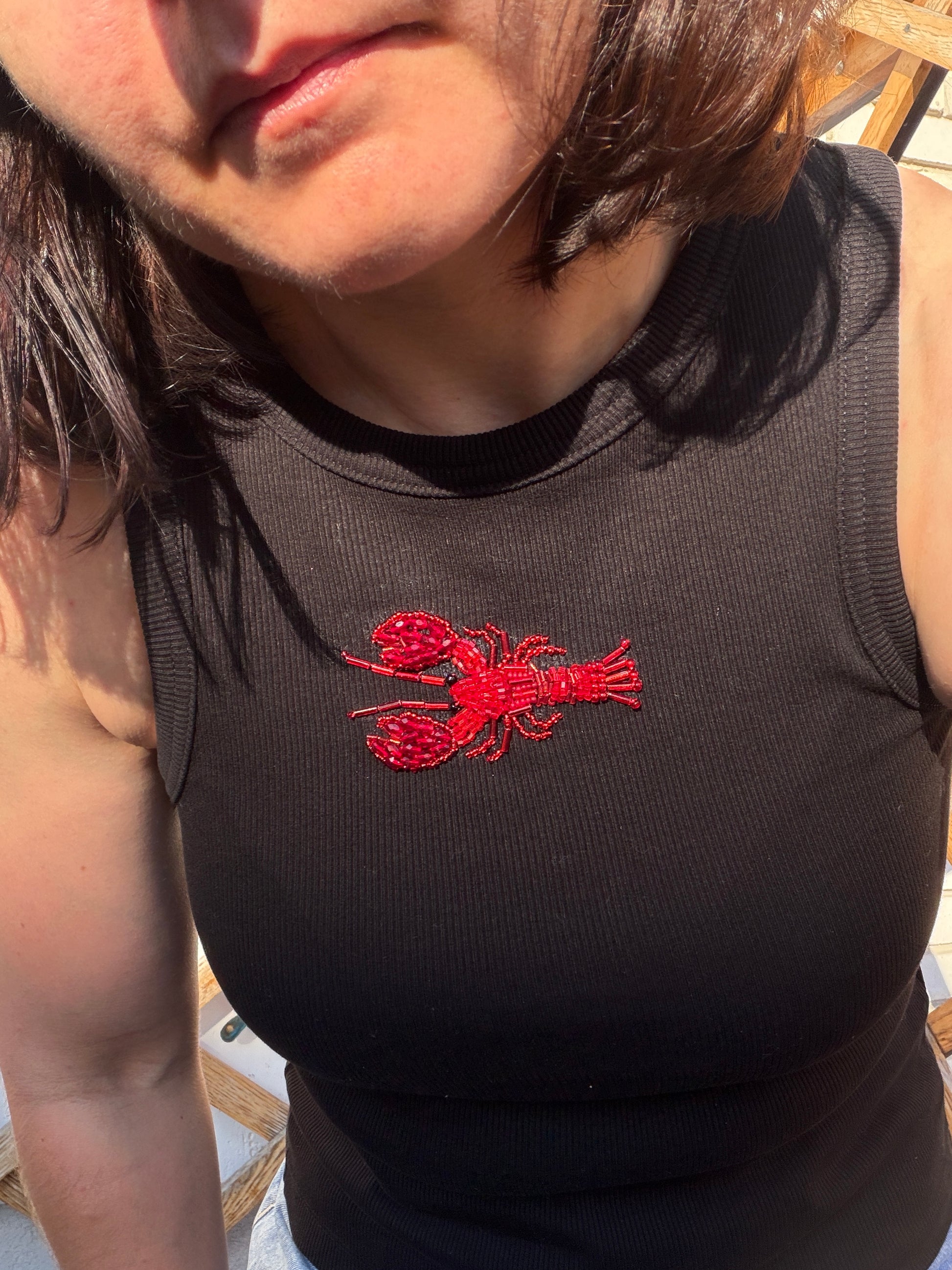 Black ribbed tank top with handmade red lobster embroidery, beaded seafood design, and wearable art detai