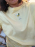 Light yellow t-shirt with a martini glass design on a plain background