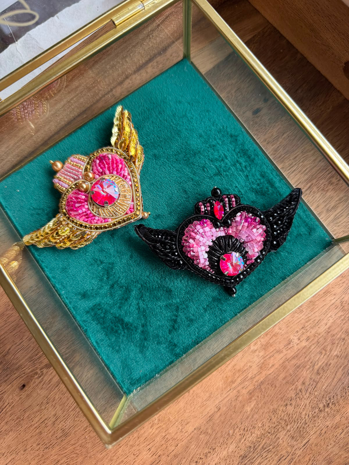 Detailed view of gold and pink Sailor Moon inspired beaded heart brooch featuring shimmering crystal accents and decorative beadwork.