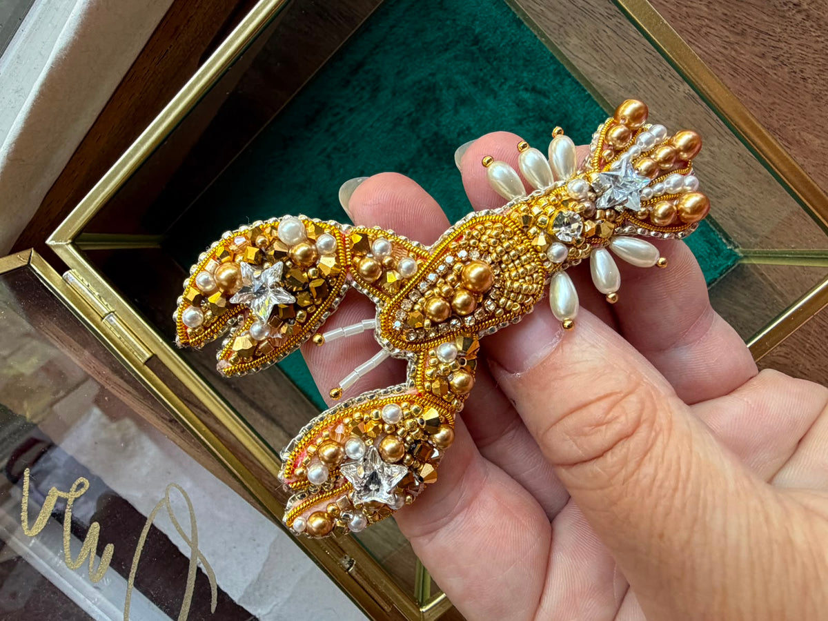 Detailed gold bead embroidery on a handmade lobster accessory featuring crystal stars, dimensional claws, and decorative pearl accents.